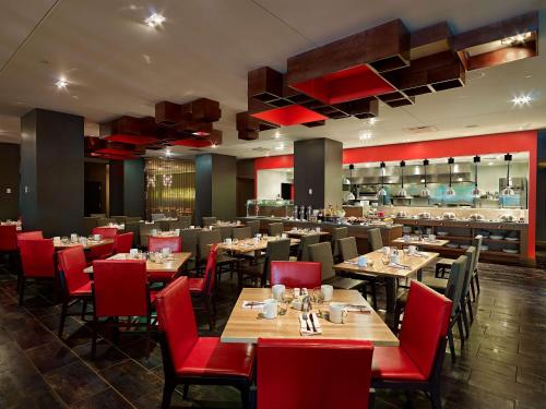 辛辛那提辛辛那提凯悦酒店的餐厅设有木桌和红色椅子