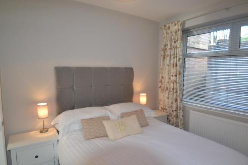 切斯特Charming 1 bed riverside apartment的卧室配有白色床、两盏灯和一扇窗户。
