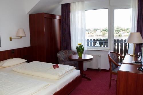 Gartow希布里克伽尼酒店的酒店客房设有床、桌子和窗户。