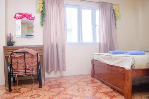 奥隆阿波朱丽斯热带公寓的一间卧室配有一张床、一张书桌和一个窗户。