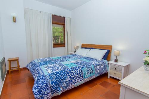 阿尔沃尔Torralta Apartment的一间卧室配有一张带蓝色棉被的床和窗户。