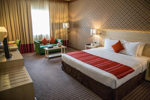 迪拜萨佛伦精品酒店的酒店客房设有一张大床和一张沙发。
