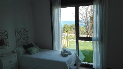希奥Casa Nueva Playa Areabrava Hio的一间卧室设有一张床和一个大窗户