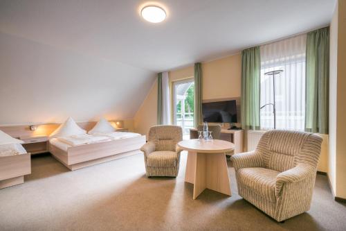 于克里茨Pension Buchfink的酒店客房配有一张床、两把椅子和一张桌子