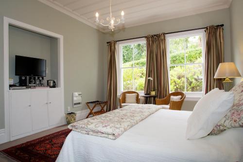 纳皮尔Cobden Garden的卧室设有白色的床和大窗户