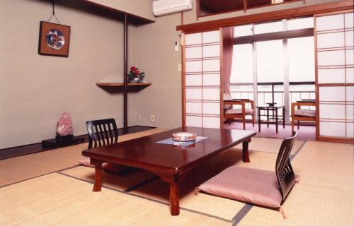 佐渡市志屋日式旅馆的客厅配有木桌和椅子