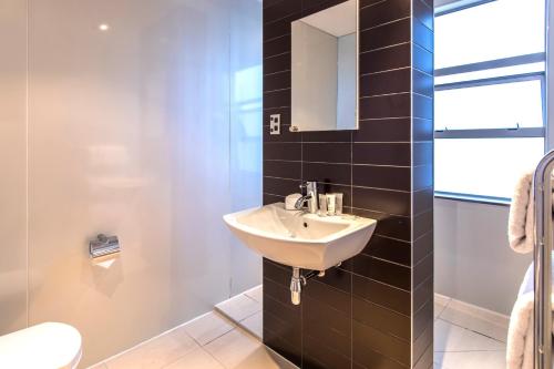奥克兰奎斯特新市场服务式公寓的一间带水槽和镜子的浴室