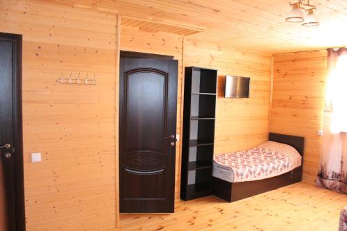 乔尔蓬阿塔Guest house Ozernaya的一间设有床铺和木墙的房间