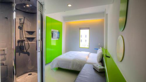 登巴萨波普！登巴萨酒店的绿色浴室设有一张床和淋浴
