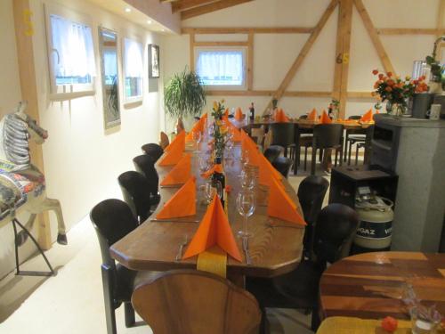 BrienzwilerEichhof Brienzwiler Berner Oberland的一张长桌,房间上放着橙色的纸船