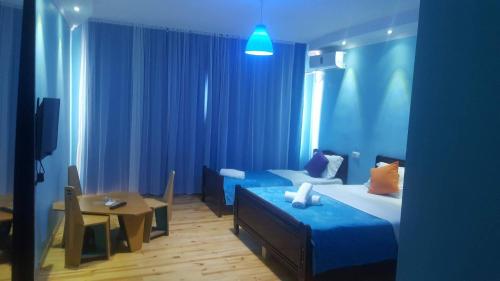 阿纳克利亚Hotel Cruise的蓝色的客房配有一张床和一张桌子