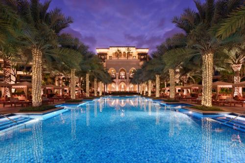 迪拜迪拜市中心皇宫酒店的一座大型游泳池,在一座建筑前种有棕榈树