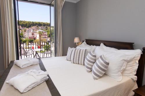 阿尔戈斯托利翁阿尼诺斯酒店的卧室配有带白色枕头的床和窗户。