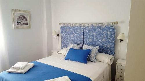 科尔多瓦Apart. Céntrico San Miguel的蓝色和白色的床,配有蓝色床头板和枕头