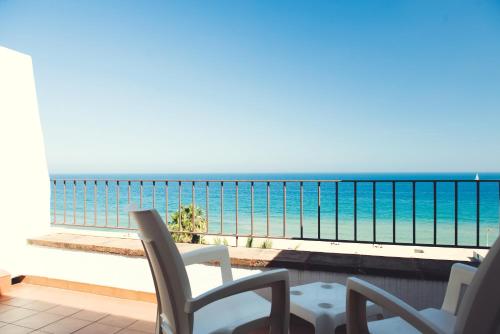 巴达洛纳巴达洛纳米拉玛酒店的阳台配有椅子,享有海景。