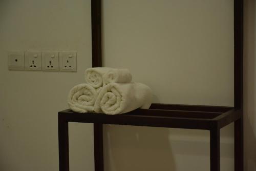 丹不拉Seasons Villa的浴室架子上堆着的毛巾
