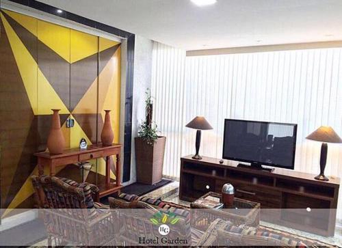 Santa MariaHotel Garden的客厅配有平面电视和沙发。