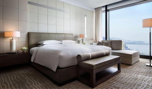 大连大连君悦酒店的一间卧室设有一张大床和一个大窗户