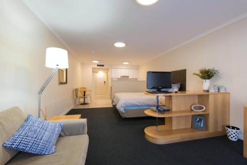悉尼海滨大道一室公寓的客厅配有床和沙发