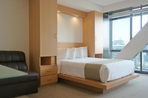 墨西哥城卡普里瑞芙尔玛410号公寓式酒店的一间卧室配有一张床、一张沙发和一个窗口