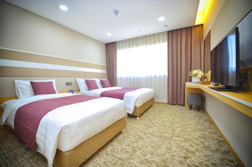 首尔东大门瑞森酒店的酒店客房设有两张床和电视。