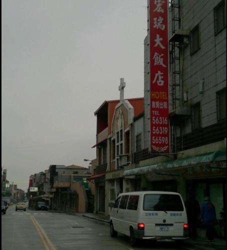 北竿宏瑞民宿的一辆白色面包车沿着建筑物旁边的街道行驶