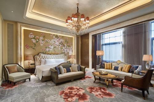 哈尔滨哈尔滨融创万达文华酒店的一间卧室配有一张床、一张沙发和椅子