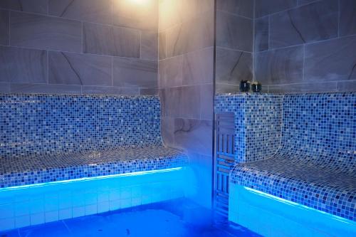 尖竹汶新旅行小屋酒店的浴室设有蓝色瓷砖墙壁和淋浴。