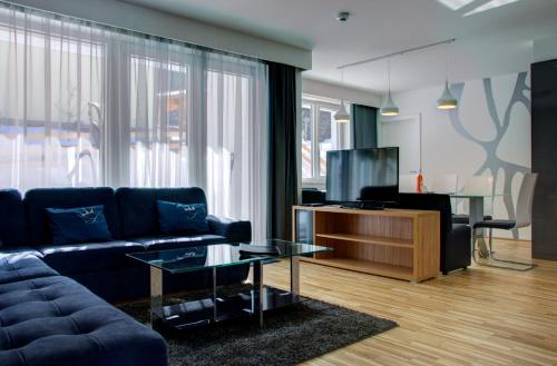恩斯塔尔豪斯恩斯塔尔豪斯西西公园酒店的客厅配有蓝色的沙发和电视