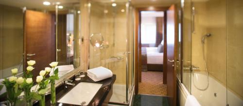 伊兹密尔伊兹密尔瑞享酒店的浴室配有盥洗盆和带镜子的淋浴