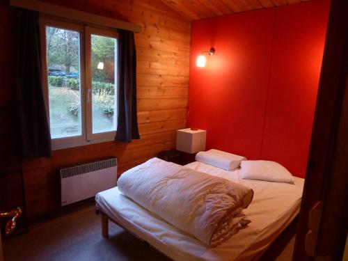 DoischeChalet Pimpernel的一间卧室配有一张红色墙壁的床