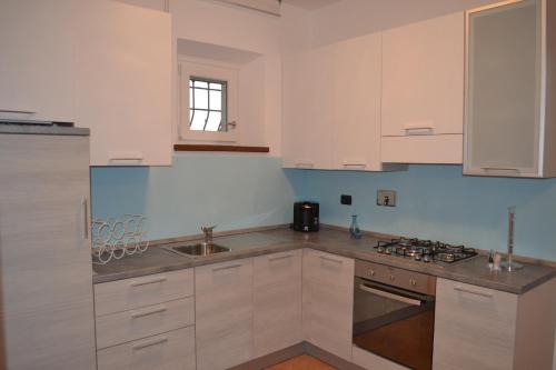 蒙特法尔科Il casale di famiglia的厨房配有白色橱柜和水槽