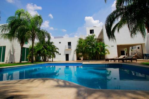 梅里达大使酒店的棕榈树屋前的游泳池
