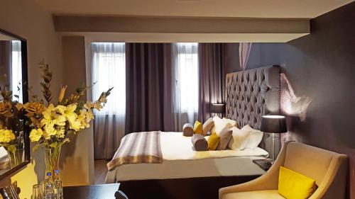 泰恩河畔纽卡斯尔利基格雷街酒店的酒店客房,配有床和椅子,鲜花