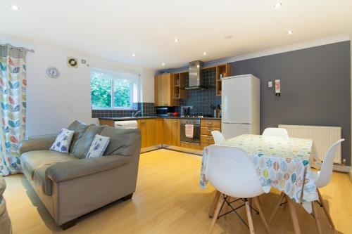 曼彻斯特Rest & Recharge - Birley View的带沙发和桌子的客厅以及厨房。