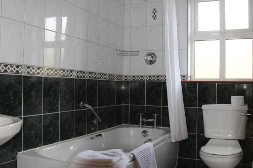 因奇Inch Beach Cottages的带浴缸、卫生间和盥洗盆的浴室
