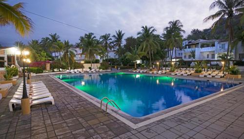 曼萨尼约维萨它普蕾雅德奥鲁曼萨尼约酒店的一个带椅子和棕榈树的大型游泳池