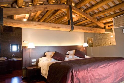 圣朱利亚德维拉托马斯阿尔贝雷达酒店的一间带一张大床的卧室,位于一个拥有木制天花板的房间