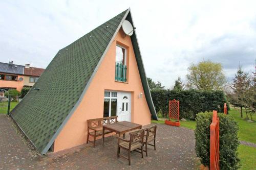 韦森贝格Finnhuette Klein Quassow SEE 9031的一个带三角形屋顶的小房子,配有桌椅