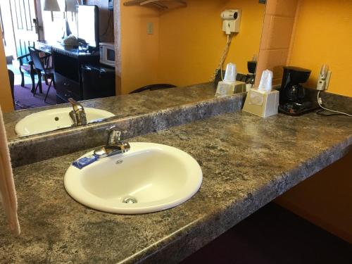 PrattPratt Budget Inn的浴室的柜台设有水槽和镜子