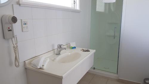 泰哈皮科奇蔓汽车旅馆的白色的浴室设有水槽和淋浴。
