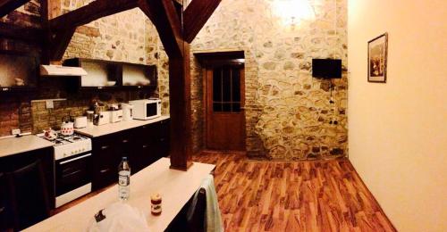 舍基Ansera Residence Sheki的铺有木地板和石墙的厨房