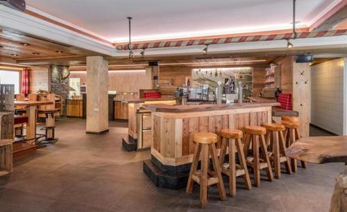 瓦格赖恩Gasthof Kogelalm的餐厅设有酒吧,配有木凳