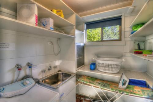 科尔斯湾科夫海滩2号公寓的一个带水槽和窗户的小厨房