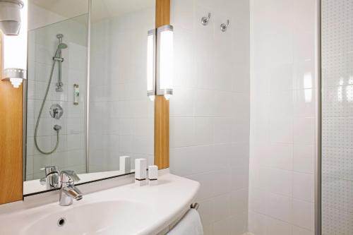 圣玛丽亚大德费拉波尔图扎欧陆公园宜必思酒店 的白色的浴室设有水槽和淋浴。