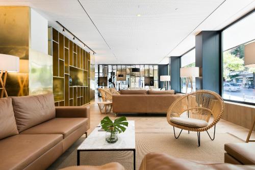 马德里梅利亚马德里塞拉诺酒店的客厅配有沙发、椅子和桌子