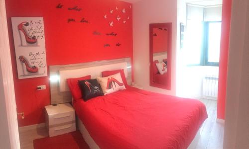 拉科鲁尼亚Apartamento En Pleno Centro的红色卧室配有红色床单