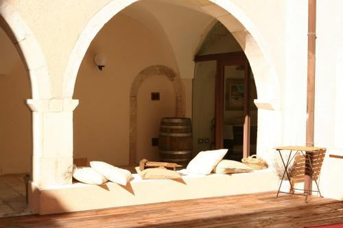 圣斯特凡诺·迪塞斯圣科伦坡修道院酒店的一间配备有枕头和桶子沙发的客房
