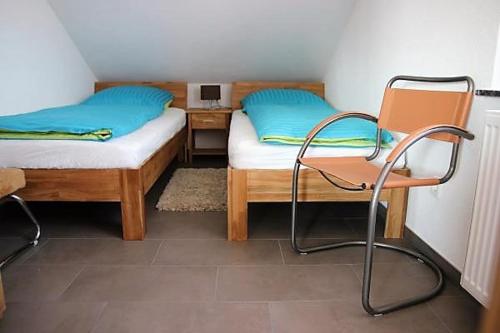 梅肯博伊伦BodenSEE Apartment Steinackerweg的客房设有两张床、椅子和书桌。