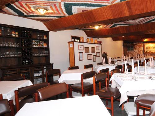 迪亚曼蒂纳Pousada do Garimpo的一间设有白色桌椅的用餐室